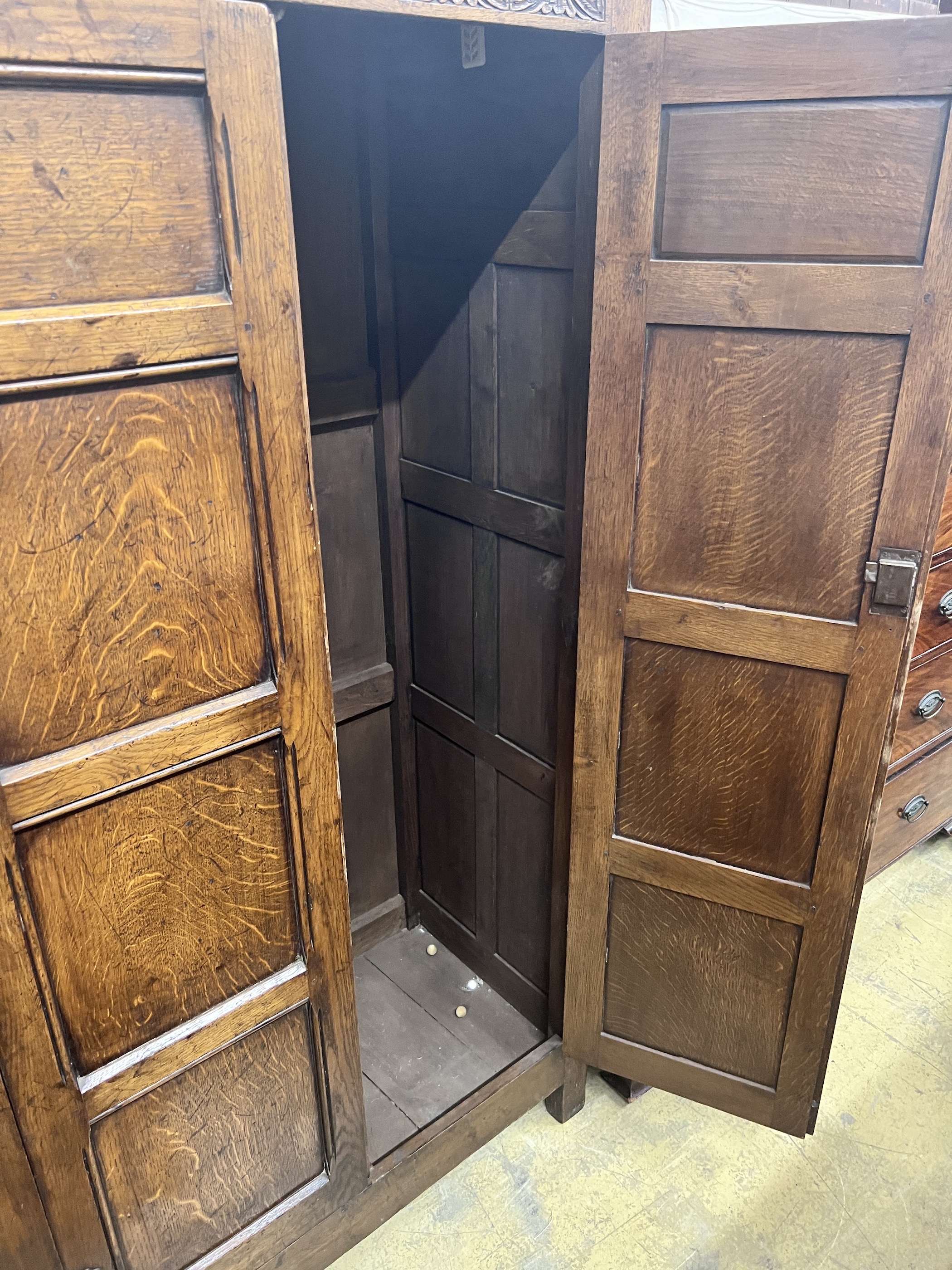 An 18th century style panelled oak hanging cupboard, width 96cm, depth 53cm, height 178cm